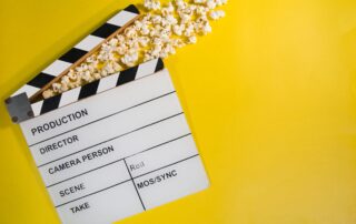 Popcorn and clapperboard on a yellow background