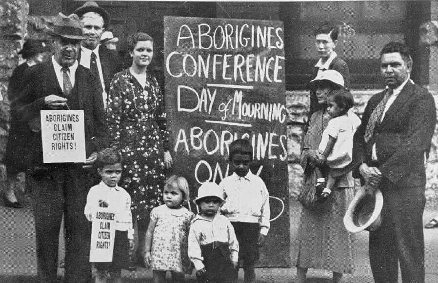 The first Day of Mourning. From the left is William Ferguson, Jack Kinchela, Isaac Ingram, Doris Williams, Esther Ingram, Arthur Williams, Phillip Ingram, Louisa Agnes Ingram OAM holding daughter Olive Ingram, and Jack Patton. The name of the person in the background to the right is not known.